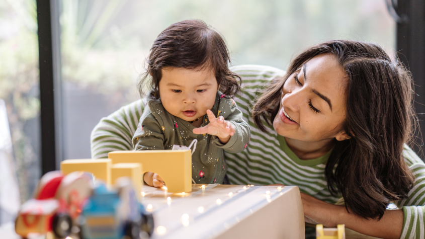 Young child and carer playing with blocks