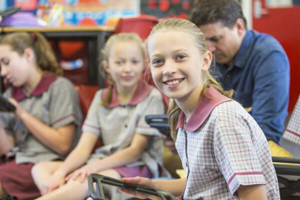 Happy School Girl Using Tablet Computer In The Classroom