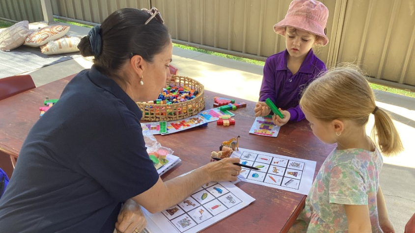 Speech therapist working with two young children
