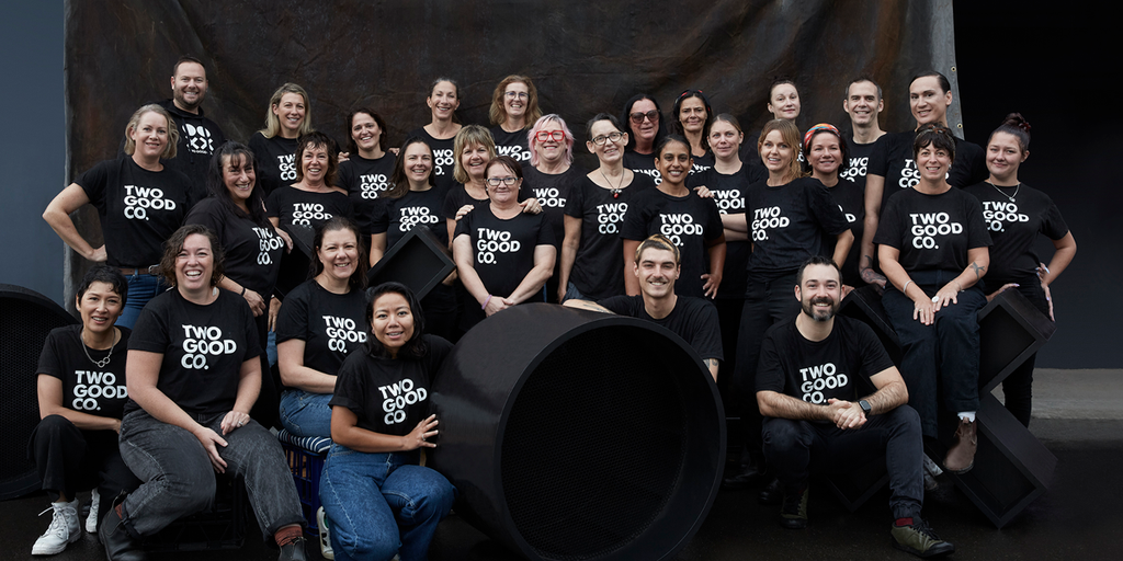 Large group of Two Good Co. team members gathered for a group photo while wearing branded team shirts.